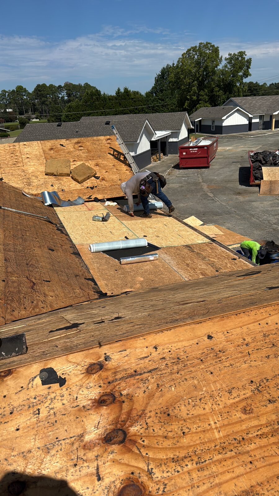 Crew replacing roof decking on an apartment building